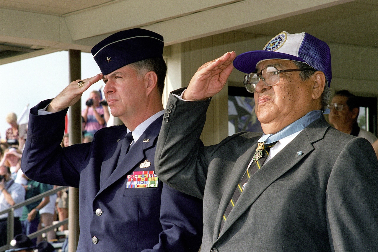 Two men standing beside each other salute.
