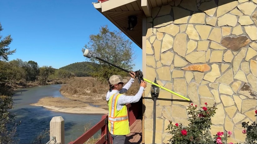 Trevor Groce measures a high-water mark Oct. 12, 2024, along the Nolichucky River in Afton, Tennessee.  By collecting accurate measurements of Hurricane Helene flood levels and their impact, the Corps of Engineers is building a foundation for more effective planning and response to future weather events.  (USACE Photo by Michael Krneta)