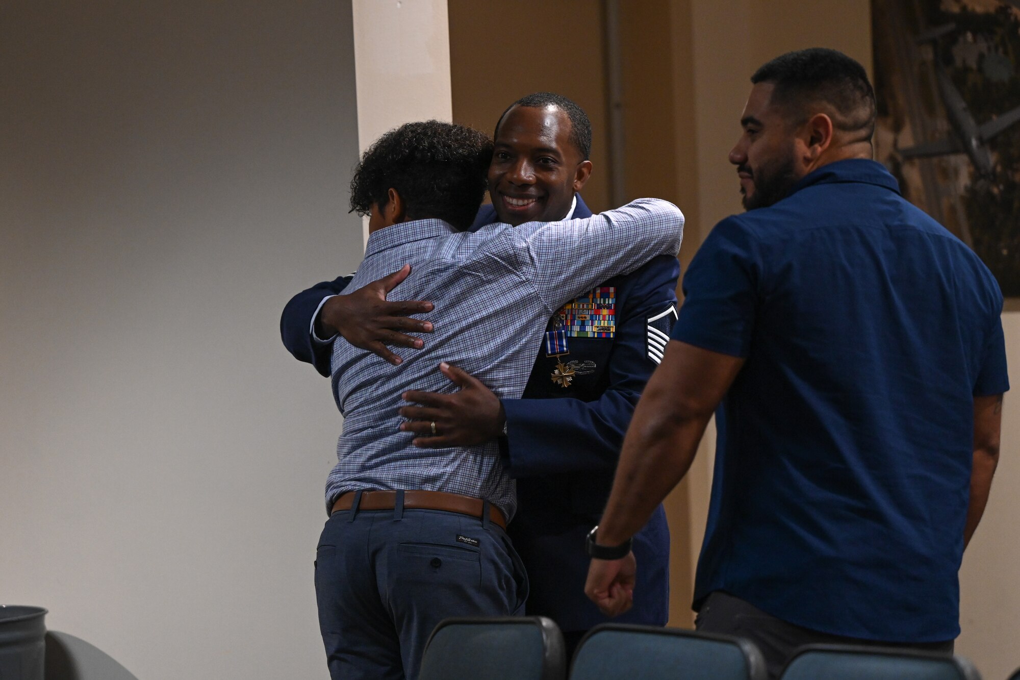 Master Sgt. Joshua Davis, 14th Weapons Squadron operations superintendent, hugs his son after being awarded the Distinguished Flying Cross medal at Hurlburt Field, Florida, Oct. 8, 2024.