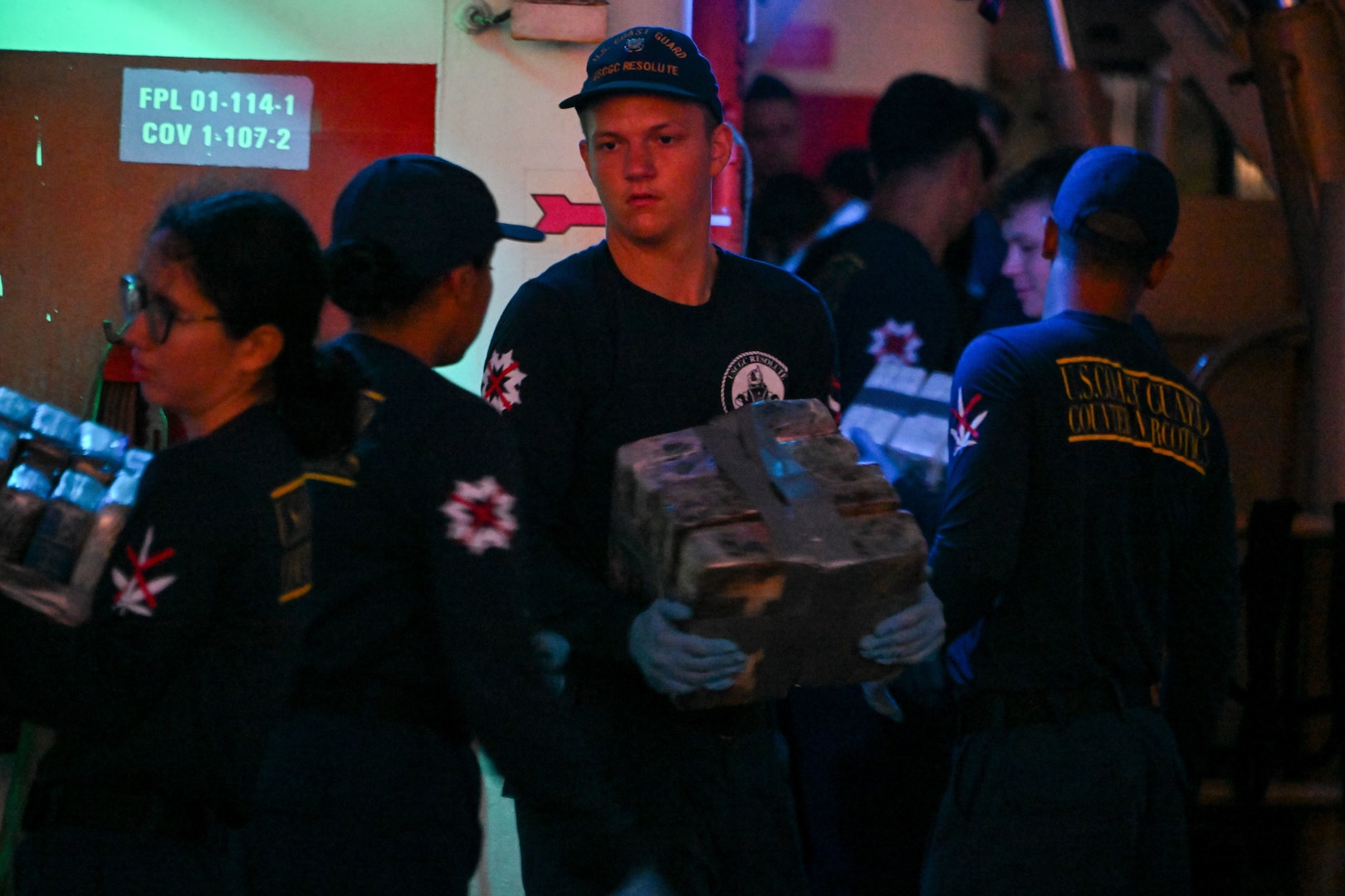 The crew of Coast Guard Cutter Resolute unload interdicted narcotics onto Sector St. Petersburg South Moorings, Florida, Oct. 23, 2024. Armed Coast Guardsmen stood watch over the interdicted drugs to ensure security and accountability of the seized contraband. (U.S. Coast Guard photo by Petty Officer 1st Class Riley Perkofski)