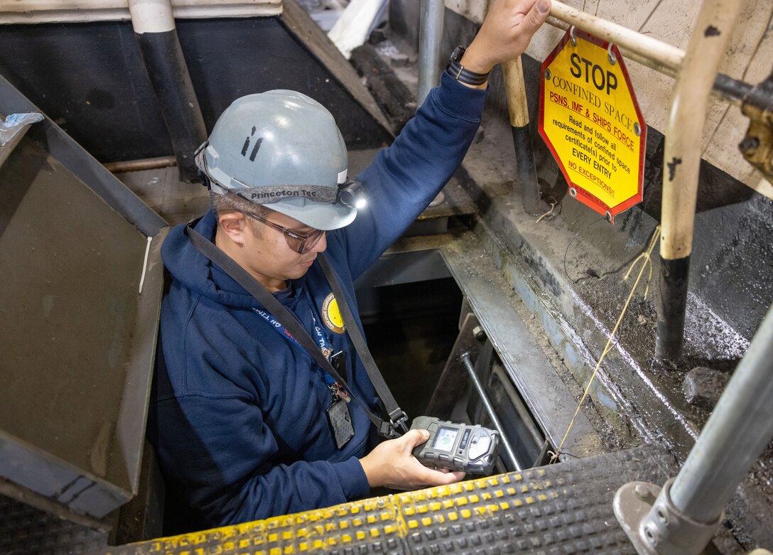 Michael Galvez, shipfitter worklead, Navy competent person, Shop 11, Shipfitters Gas Free, works inside the roller pit of a large flange turning machine, Oct. 18, 2024, while completing a gas-free inspection in Building 460 at Puget Sound Naval Shipyard & Intermediate Maintenance Facility in Bremerton, Washington. (U.S. Navy photo by Wendy Hallmark)