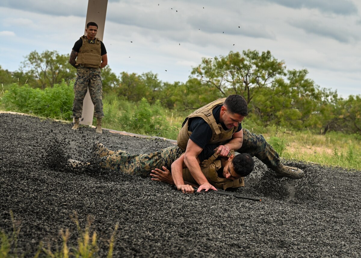 U.S. Marine Sgt. Nathan Nanez and Staff Sgt. Zachary Wales perform a Marine Martial Arts demonstration at the Marine Detachment, Goodfellow Air Force Base, Texas, Oct. 18, 2024. The Marines demonstrated techniques two individuals may use when fighting for control of a weapon. (U.S. Air Force photo by Senior Airman Zach Heimbuch)