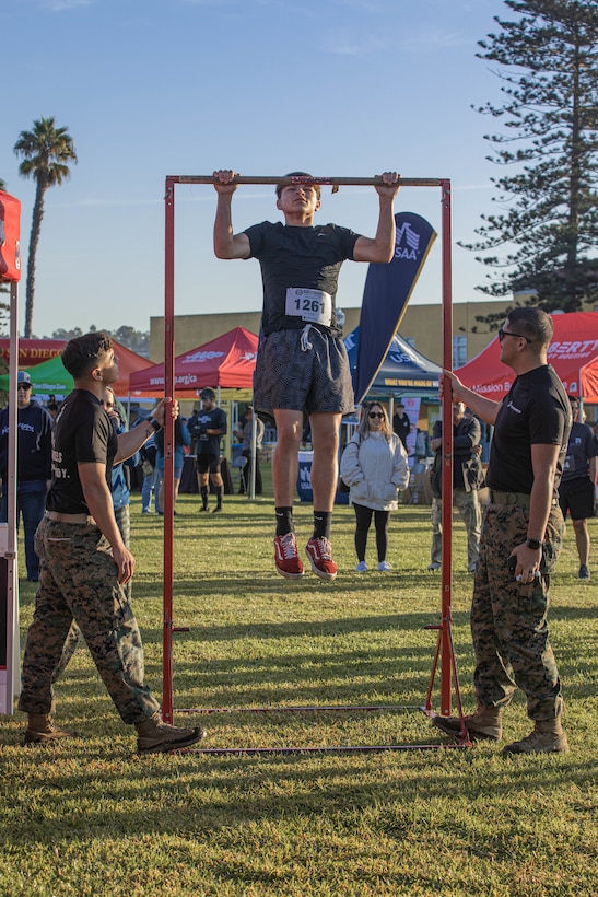 U.S. Marines from the Western Recruiting Region hold the pull-up bar for a participant during the 2024 Marine Corps Recruit Depot San Diego Boot Camp Challenge at MCRD San Diego, California, Oct. 19, 2024. For the past 23 years, MCRD San Diego has hosted the MCRD San Diego Boot Camp Challenge, a three-mile obstacle course race guided by 60 drill instructors that highlights the physical and mental demands of boot camp. The event fosters comradery and community engagement through interaction with MCRD personnel. (U.S. Marine Corps photo by Cpl. Alexandra M. Earl)