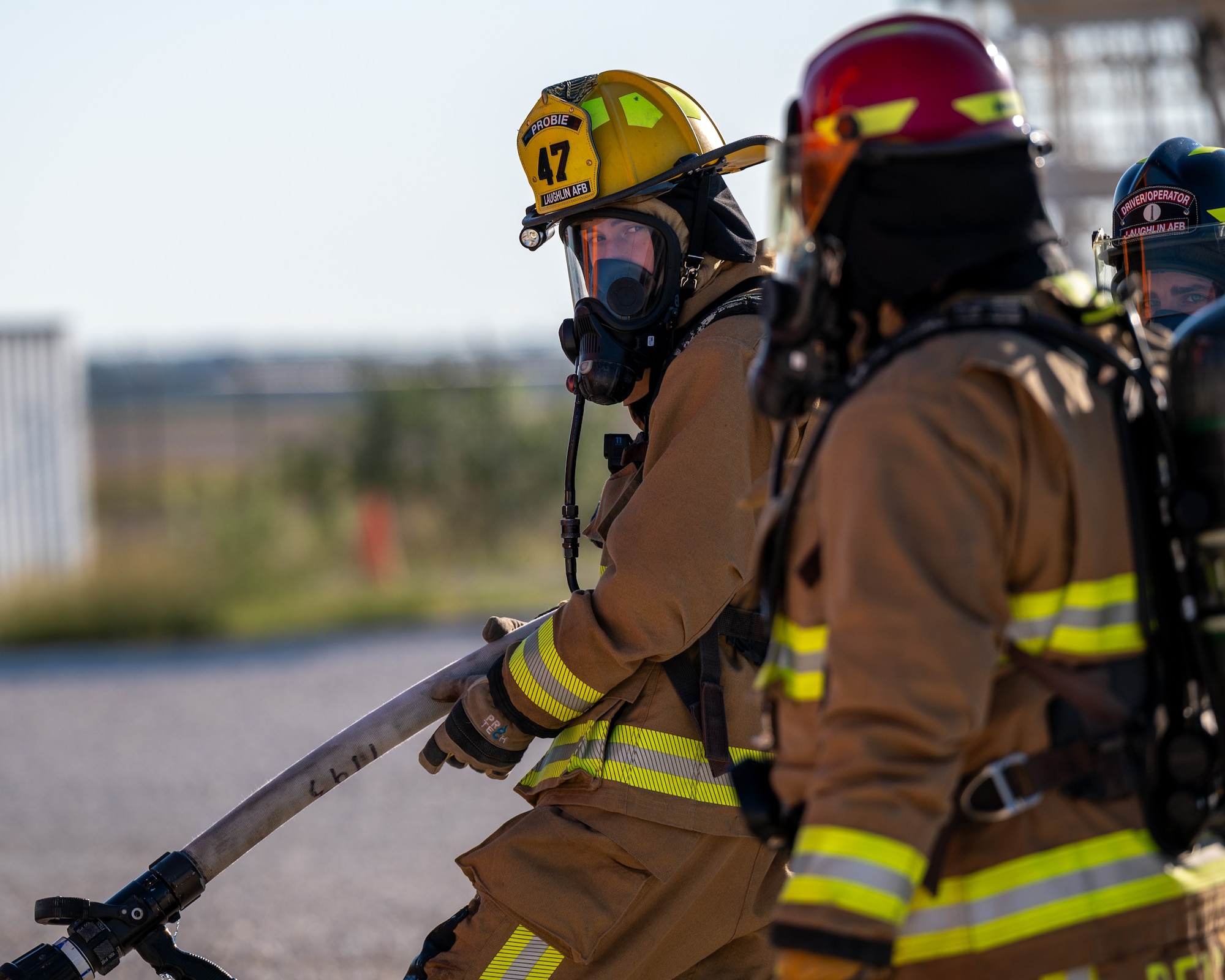 Firefighters from the 47th Civil Engineer Squadron converse about the upcoming training fire at Laughlin Air Force Base, Texas, Oct. 15, 2024. Training fires put Airmen to the test, stressing them with real heat, flames and pressure. (U.S. Air Force photo by Staff Sgt. Nicholas Larsen)