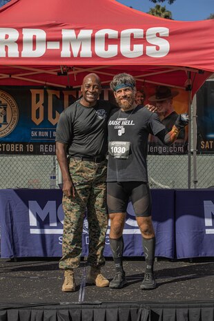 U.S. Marine Corps Brig. Gen. James A. Ryans II, commanding general, Marine Corps Recruit Depot San Diego and Western Recruiting Region, poses with Erik Weber, the 2nd place male participant of the 2024 MCRD San Diego Boot Camp Challenge at MCRD San Diego, California, Oct. 19, 2024. For the past 23 years, MCRD San Diego has hosted the MCRD San Diego Boot Camp Challenge, a three-mile obstacle course race guided by 60 drill instructors that highlights the physical and mental demands of boot camp. The event fosters comradery and community engagement through interaction with MCRD personnel. (U.S. Marine Corps photo by Cpl. Alexandra M. Earl)