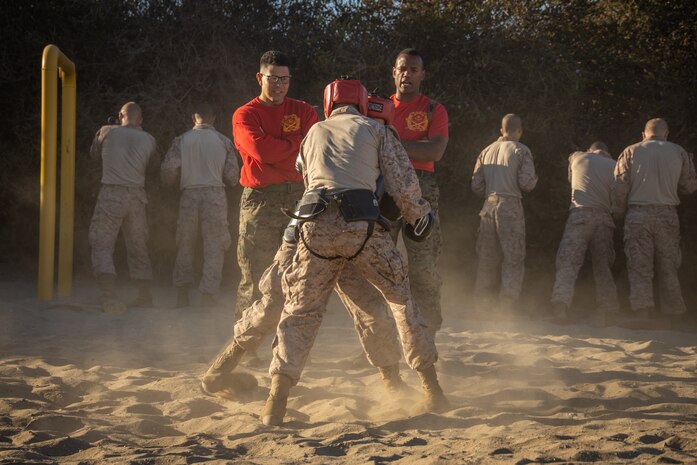 U.S. Marine Corps 1st Lt. Ian Nelson, right, series commander and Staff Sgt. Elija Taylor, left, a drill instructor with Alpha Company, 1st Recruit Training Battalion, observes a body sparring event at Marine Corps Recruit Depot San Diego, California, Oct. 21, 2024. Recruits are taught Marine Corps Martial Arts Program techniques, which instill basic self-defense that they will execute throughout recruit training during events like body sparring and pugil sticks to help build a warrior ethos and esprit de corps. (U.S. Marine Corps photo by Lance Cpl. Janell B. Alvarez)