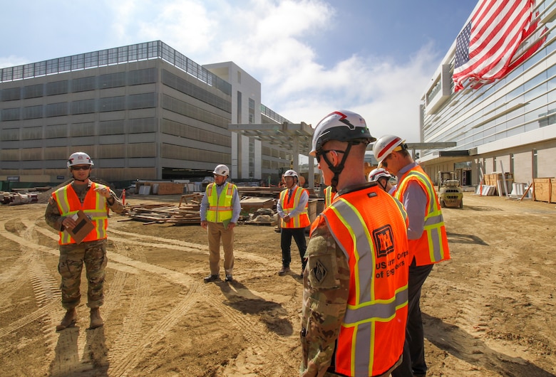 Capt. Gregory Sacenti, project engineer with the U.S. Army Corps of Engineers Los Angeles District, left, leads a tour Oct. 9 for senior leaders with Headquarters USACE and the Department of Veterans Affairs of the Spinal Cord Injury/Community Living Center, visible at right, at the Jennifer Moreno DVA Medical Center campus in San Diego. Behind Sacenti is the 1,000-plus-space, seven-level parking structure, which was opened in July 2023. Brig. Gen. Kirk Gibbs, deputy commanding general for Military and International Operations at USACE, foreground-right, took part in the tour.