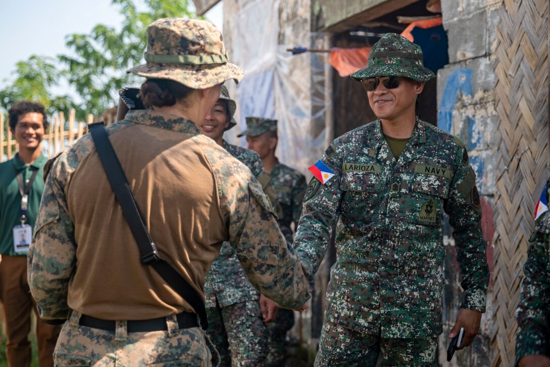 U.S. Marine Corps Maj. Melanie Roy, left, the technical information operations officer assigned to the 15th Marine Expeditionary Unit, and a native of California, shakes hands with a Philippine Marine assigned to Intelligence Company, 3rd Marine Brigade, following a counter-unmanned aircraft system subject matter expert exchange during exercise KAMANDAG 8 at Tarumpitao Point, Palawan Province, Philippines, Oct. 18, 2024. KAMANDAG is an annual Philippine Marine Corps and U.S. Marine Corps-led exercise aimed at enhancing the Armed Forces of the Philippines’ defense and humanitarian capabilities by providing valuable training in combined operations with foreign militaries in the advancement of a Free and Open Indo-Pacific. This year marks the eighth iteration of this exercise and includes participants from the French Armed Forces, Royal Thai Marine Corps, and Indonesian Marine Corps; including continued participation from the Australian Defense Force, British Armed Forces, Japan Ground Self-Defense Force, and Republic of Korea Marine Corps. (U.S. Marine Corps photo by Sgt. Amelia Kang)