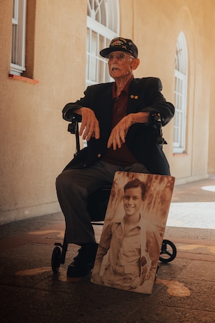 Retired U.S. Marine Corps Maj. Billy Hall, a veteran of World War II, the Korean War, and Vietnam War, poses with a photo of his younger self when he was serving in WWII at Guadalcanal on the Yellow Footprints at Marine Corps Recruit Depot San Diego, California, Oct. 11, 2024. Hall visited MCRD San Diego to attend a graduation ceremony for Bravo Company, 1st Recruit Training Battalion. (U.S. Marine Corps photo by Cpl. Alexander O. Devereux)