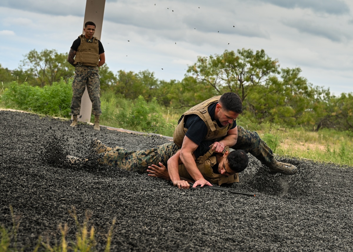 U.S. Marine Sgt. Nathan Nanez and Staff Sgt. Zachary Wales perform a Marine Martial Arts demonstration at the Marine Detachment, Goodfellow Air Force Base, Texas, Oct. 18, 2024. The Marines demonstrated techniques two individuals may use when fighting for control of a weapon. (U.S. Air Force photo by Senior Airman Zach Heimbuch)