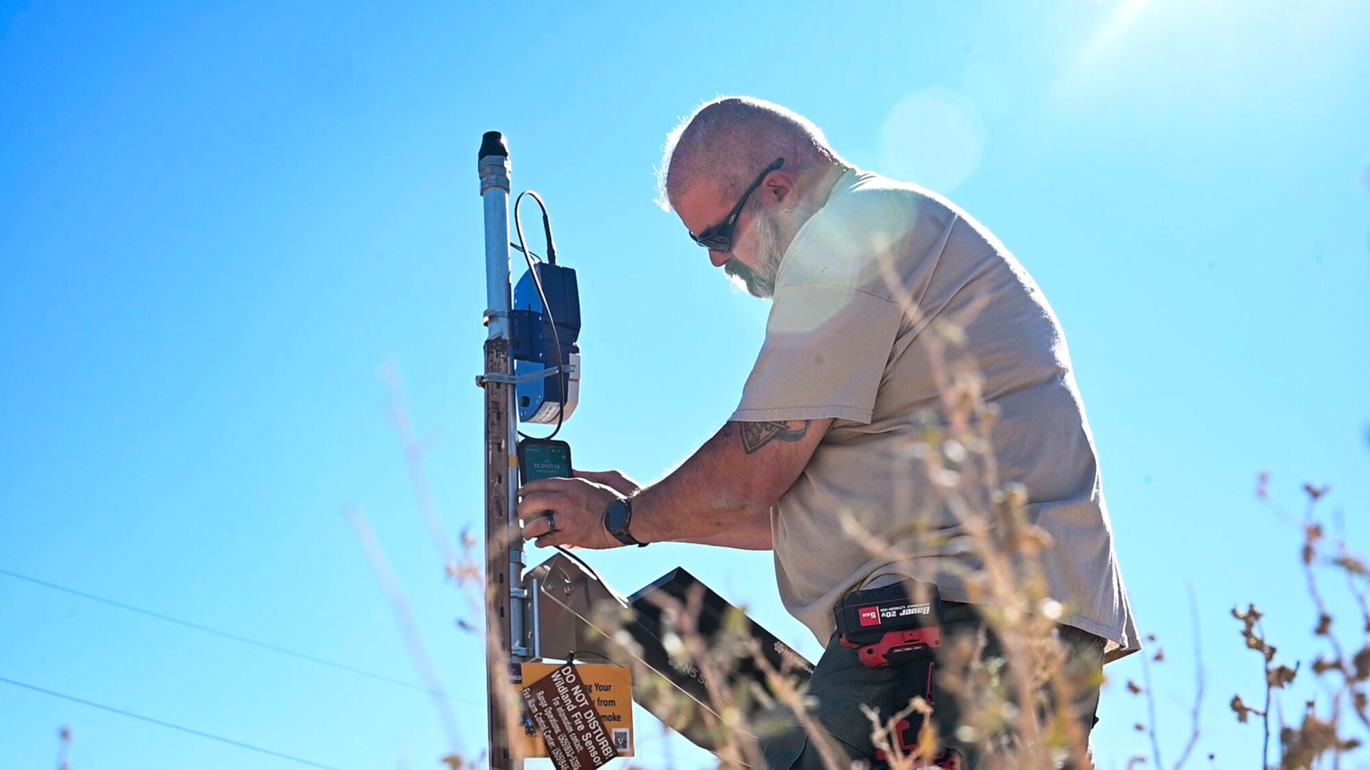 Man installs a sensor on post