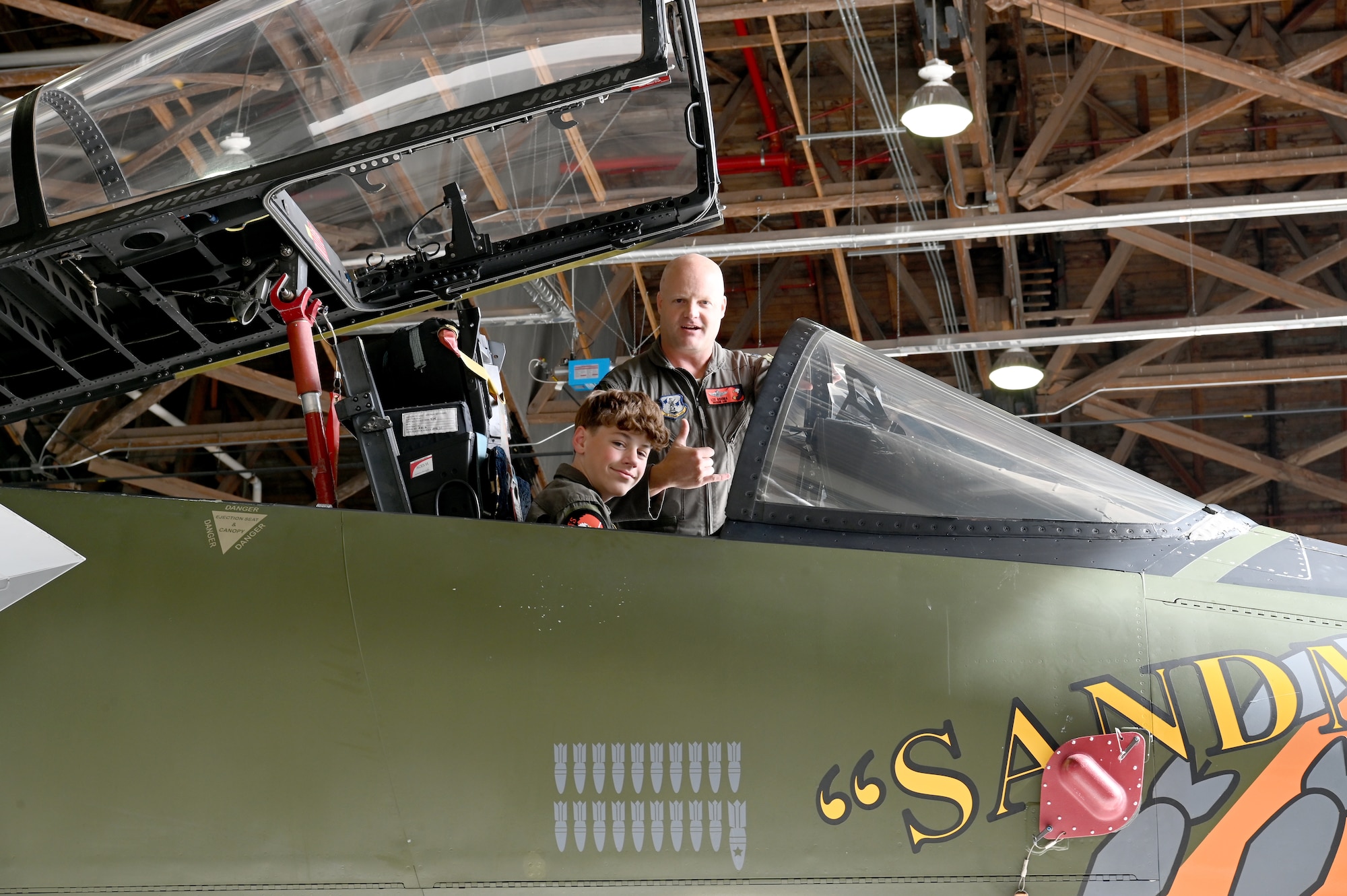 Carsen “Deadshot” Darnell, an 11-year-old local middle schooler who is currently battling spinal cancer, stop to pose for a picture with U.S. Air Force Col. Lee Bouma, 173rd Fighter Wing commander, while he sat in the cockpit of the wing heritage jet, at Kingsley Field in Klamath Falls, Oregon.