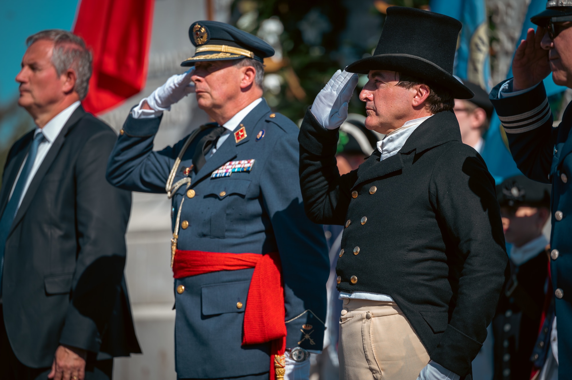 A reenactor dressed in a colonial outfit salutes.