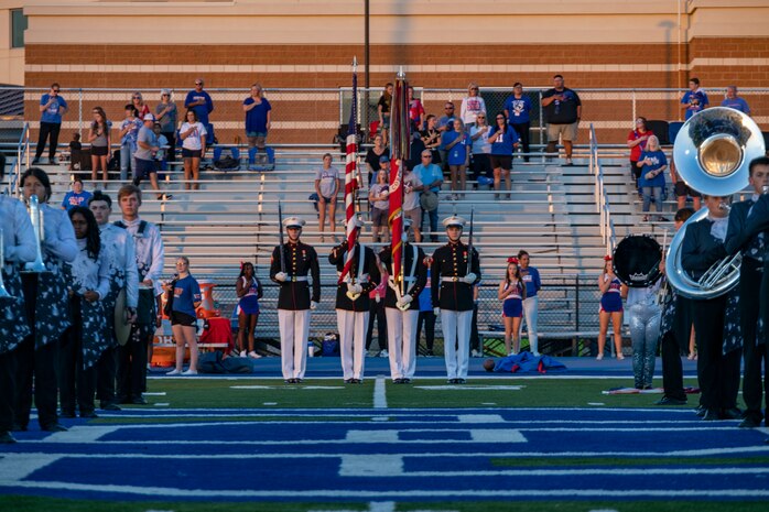 Marines with the U.S. Marine Corps Color Guard prepare to march the National Ensign and the U.S. Marine Corps Battle Colors as part of a football stadium dedication ceremony at Deer Creek High School, Edmond, Okla., Oct. 11, 2024. The Deer Creek High School football stadium was dedicated and renamed in honor of U.S Marine Corps Maj. Tyler Tidwell, a graduate of Deer Creek High School, who lost his battle to amyotrophic lateral sclerosis (ALS) in 2022. (U.S. Marine Corps photo by Sgt. Lennon Dregoiw)