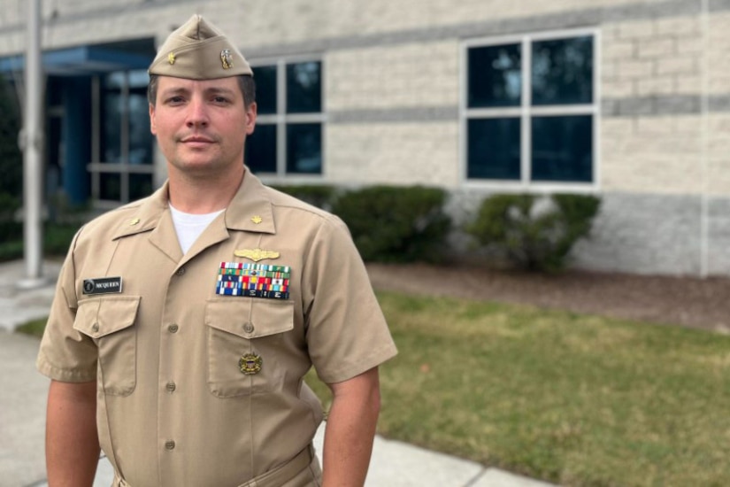 A Navy officer poses for a photo.