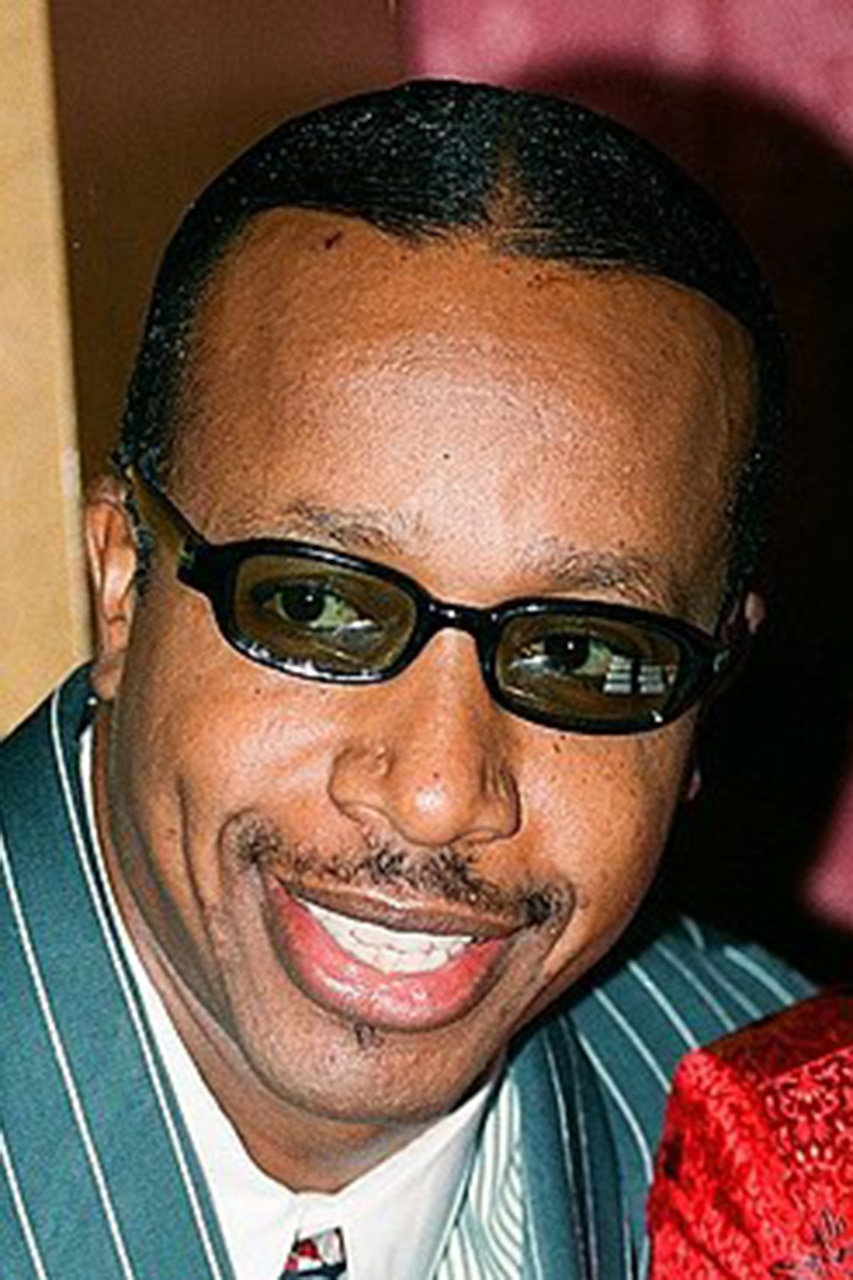 Close-up of a smiling person wearing sunglasses.