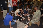 An instructor with the Combat Medic Specialist Training Course at the Medical Education and Training Campus (METC) helps high school students conduct a mock blood transfusion during the Military Medicine Career Fair/Recruiting Event on Joint Base San Antonio-Fort Sam Houston October 11. The Military Medicine Career Fair was a collaboration between METC, the Navy Medical Training Support Center, U.S. Army Medical Center of Excellence, and Air Force 59th Training Group to support military medicine recruiting efforts.
