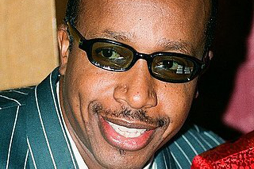 Close-up of a smiling person wearing sunglasses.