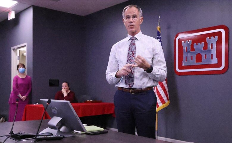 Man giving presentation in front of a table.