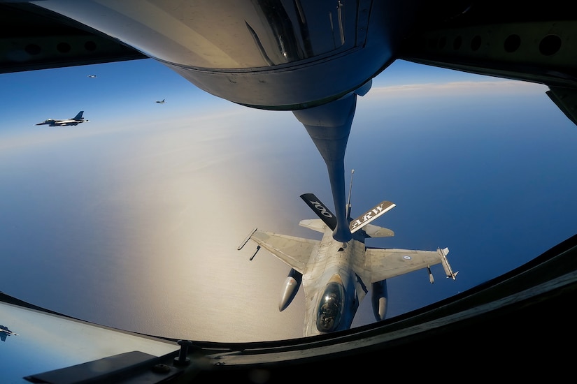 A military fighter jet is refueled in midair.