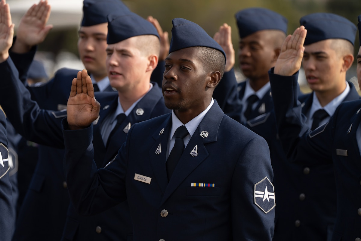 Several guardians stand in formation and speak with their right hands raised.