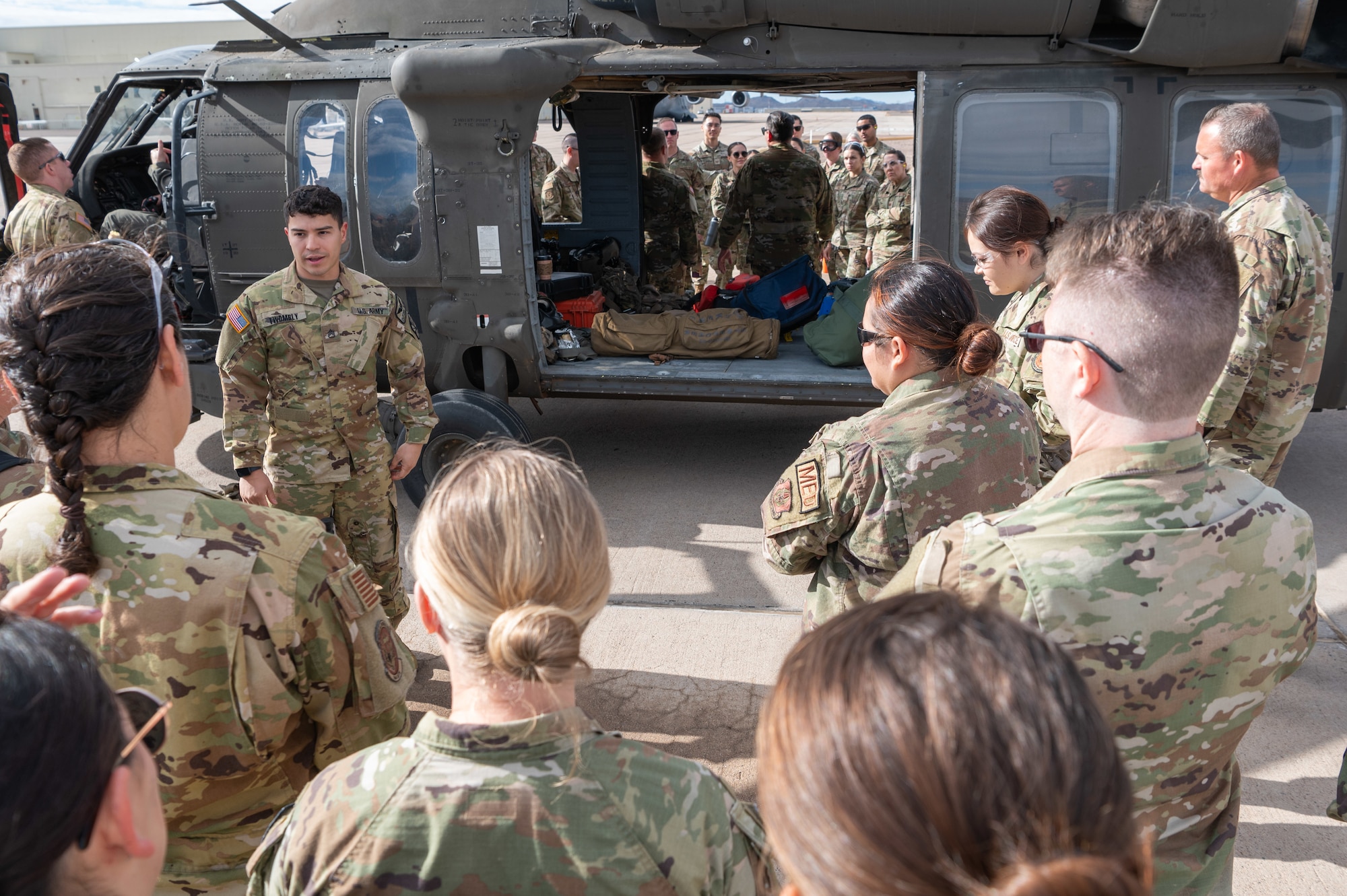 An Arizona Army National Guard Soldier provides an overview of UH-60 Black Hawk helicopter operations to 944th Fighter Wing Reserve Citizen Airmen during joint medevac training at Goodyear Phoenix Airport, Goodyear, Ariz., Oct. 19, 2024. The exercise aimed to familiarize Airmen with helicopter patient evacuation procedures in preparation for the November Exercise Desert Hammer 25-1. (U.S. Air Force photo by Senior Airman Alexis Orozco)