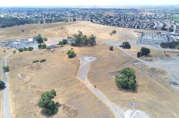 An aerial photo shows remnants of the Former Beale Air Force Base Titan 1-A missile complex in Lincoln, California, signified by the circular silo cover in the center of the photo. The Sun City Lincoln Hills community can be seen in the distance.