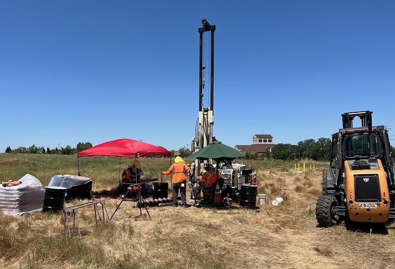 Workers operate machinery that will collect groundwater samples.