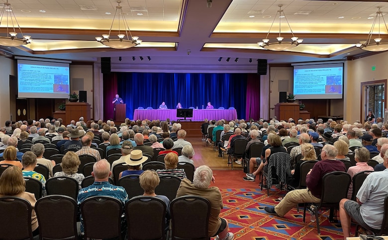 A ballroom with hundreds of seated spectators as U.S. Army Corps of Engineers representatives present from a stage.