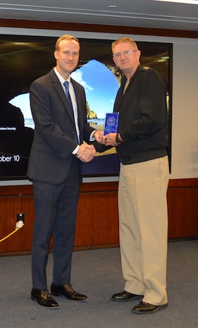 WASHINGTON NAVY YARD (10 October, 2024) – Strategic Systems Programs (SSP) Assistant Counsel James Gulliksen (left) shakes hands with SSP Director Vice Adm. Johnny Wolfe Jr. (right) during a ceremony recognizing him for earning the Department of the Navy Office of the General Counsel Junior Attorney Achievement Award. The award recognizes an attorney who has begun working in the practice of law within the past five years and who has performed above and beyond expectations, showing an outstanding ability to effectively digest and disseminate information. Gulliksen, who specializes in nonproliferation and international law, has played a crucial role in SSP’s relationship with international partners and has proven invaluable in supporting the Polaris Sales Agreement and Mutual Defense Agreement with the United Kingdom. SSP is the Navy command that provides cradle-to-grave lifecycle support for the sea-based leg of the nation's nuclear triad. This includes training, systems, equipment, facilities and personnel responsible for ensuring the safety, security, and effectiveness of the nation's Submarine Launched Ballistic Missile (SLBM) Trident II (D5LE) Strategic Weapon System.
