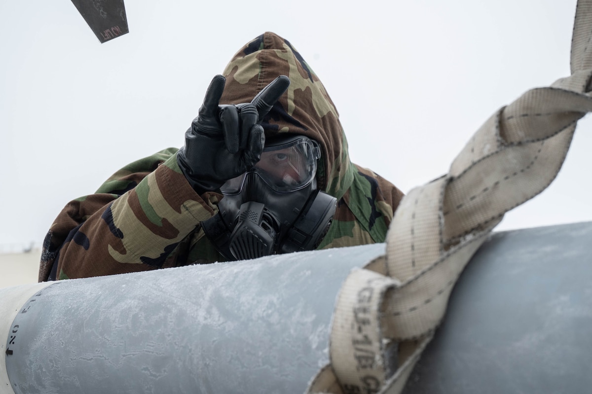 U.S. Air Force Senior Airman Joshua Hughes, 356th Fighter Generation Squadron munitions specialist, brandishes the squadron’s gesture during the third quarter load competition at Eielson Air Force Base, Alaska, Oct. 18, 2024.