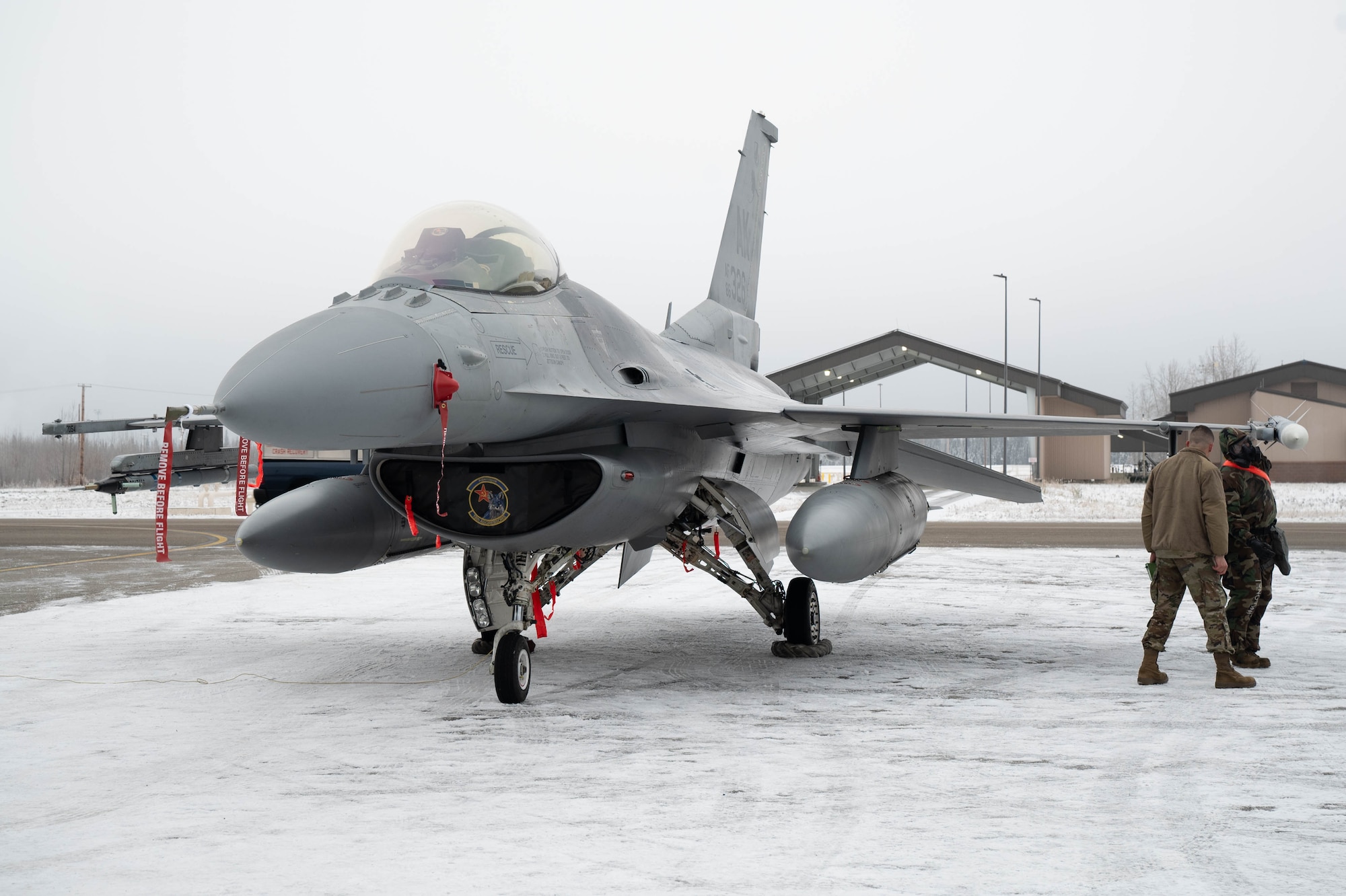 U.S. Airmen from the 18th Fighter Generation Squadron check the placement of an AIM-120 Advanced Medium-Range Air-to-Air Missile on an F-16 Fighting Falcon aircraft during the third quarter load competition at Eielson Air Force Base, Alaska, Oct. 18, 2024.