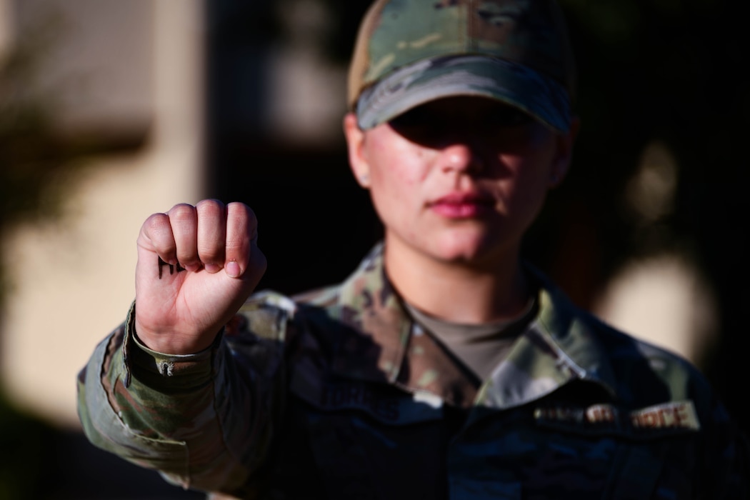 U.S. Air Force Airman 1st Class Lauren Torres displays the universal hand signal for domestic abuse at Altus Air Force Base, Oklahoma, Oct. 24, 2024. Throughout the month, Airmen from Altus AFB highlighted resources both on base and in the community to shed light on domestic violence and empower victims. (U.S. Air Force photo by Senior Airman Miyah Gray)