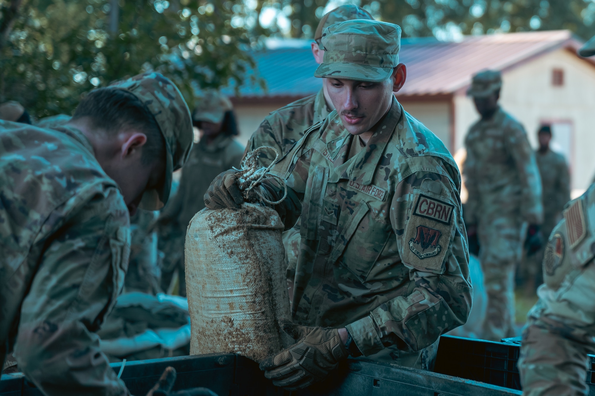 An Airman grabs a sandbag.