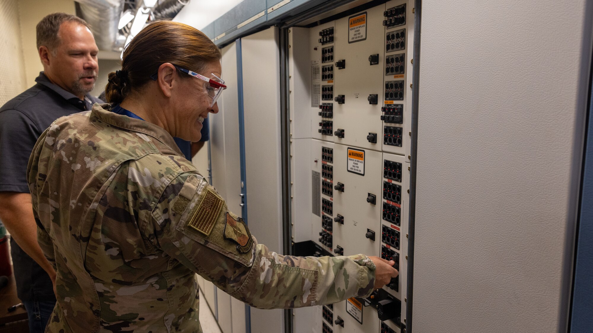 woman flipping fuse in server room