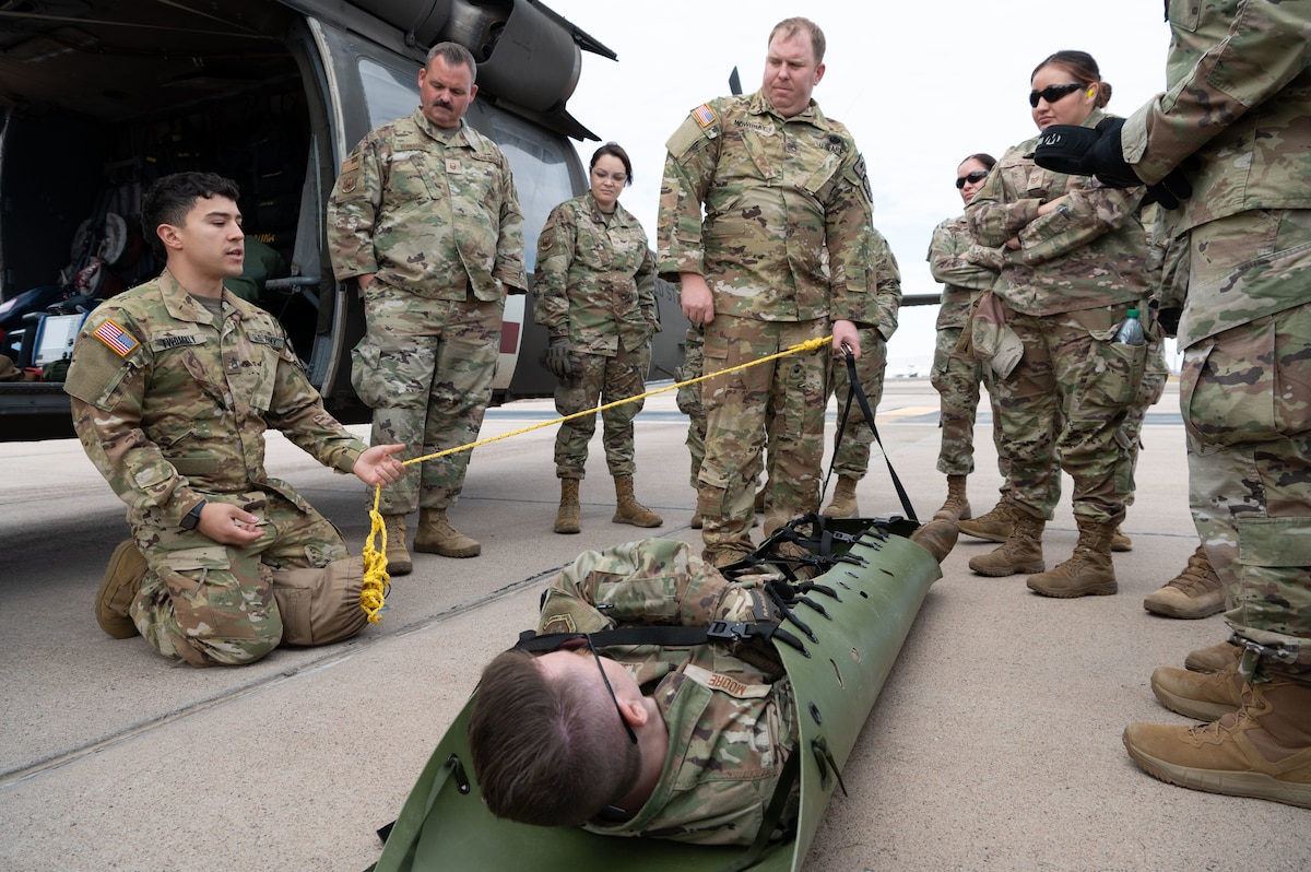 Arizona Army National Guard Soldiers demonstrate the use of a litter to 944th Fighter Wing Reserve Citizen Airmen during joint medevac training at Goodyear Phoenix Airport, Goodyear, Ariz., Oct. 19, 2024. The training prepared both units for upcoming missions, including Exercise Desert Hammer 25-1 in November. (U.S. Air Force photo by Senior Airman Alexis Orozco)