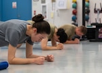 U.S. Air Force Airman 1st Class Tatyana Khitlik, left, Airman 1st Class Marcia Dubon, center, and Airman 1st Class Evan Studley, all 62d Maintenance Squadron avionics technicians, perform group training exercises at Joint Base Lewis-McChord, Washington, October 21, 2024. The group training is facilitated by the 62d Medical Support Squadron Operational Support Team and offers Airmen resiliency training, preventative health care and physical training support. (U.S. Air Force photo by Airman 1st Class Megan Geiger)