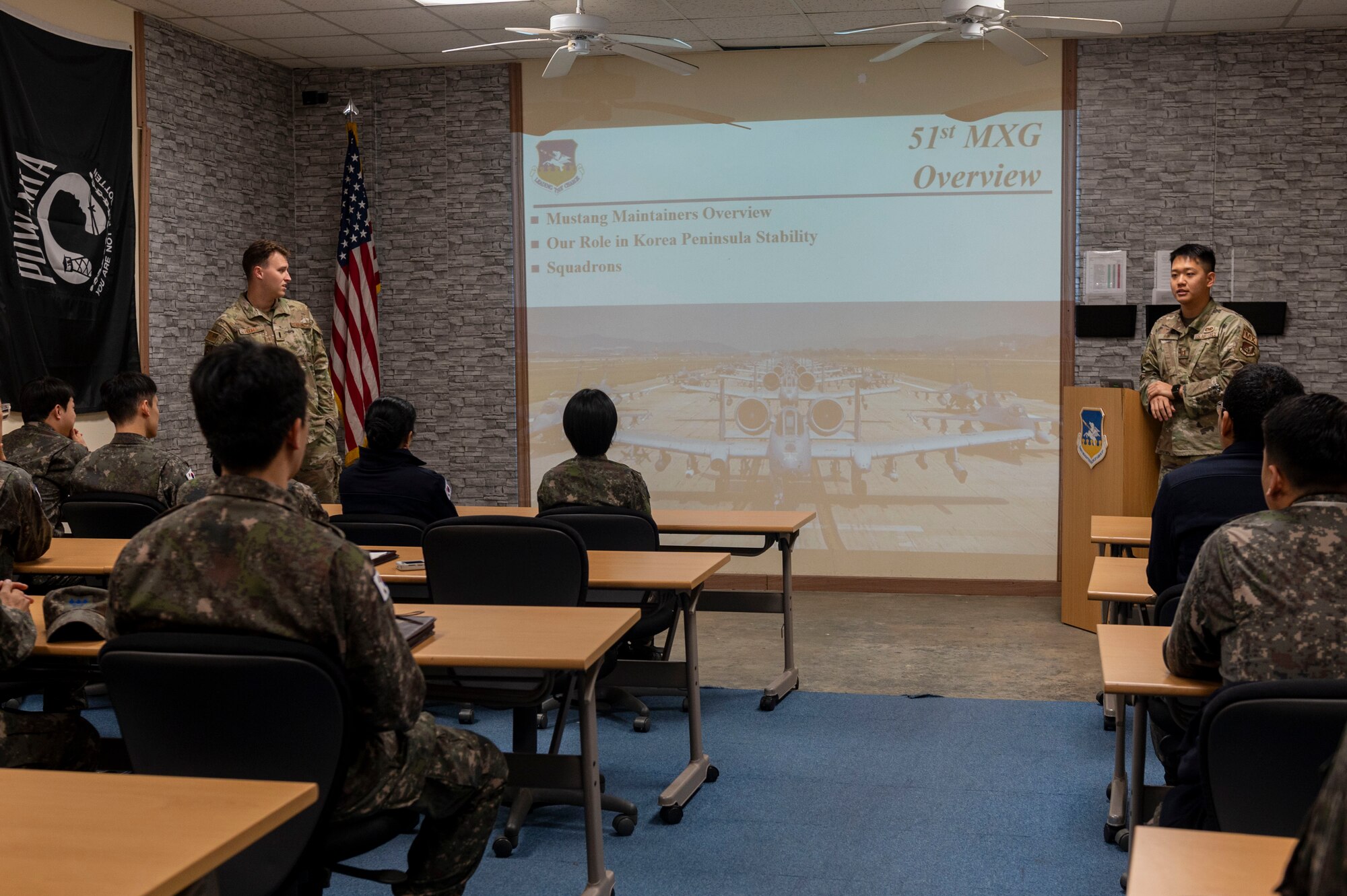 U.S. Air Force 1st Lt. Bryce Hughes, 51st Maintenance Group maintenance operations flight officer in charge, and Capt. Michael Shin, 36th Fighter Generation Squadron sortie generation flight commander, give a mission brief during a Republic of Korea Air Force Maintenance Immersion Tour at Osan Air Base, ROK, Oct. 21, 2024. Throughout the tour, ROKAF Airmen engaged in demonstrations and discussions with Osan AB personnel, gaining critical knowledge about aircraft maintenance, procedures and logistical operations. (U.S. Air Force photo by Senior Airman Kaitlin Frazier)