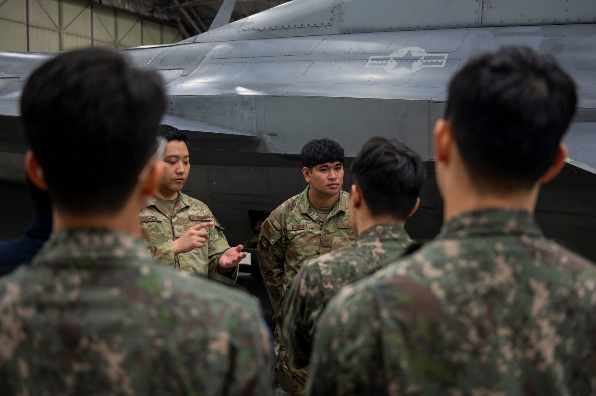 U.S. Air Force Staff Sgt. Jean Carlo Miranda, 51st Maintenance Group squadron load crew team member, briefs Republic of Korea Air Force Airmen on the F-16 Fighting Falcon during a ROKAF Maintenance Immersion Tour at Osan Air Base, Republic of Korea, Oct. 21, 2024. The tour aimed to provide ROKAF maintenance and logistics officers with insights into the operational practices and strengthen relationships between ROKAF and USAF service members. (U.S. Air Force photo by Senior Airman Kaitlin Frazier)