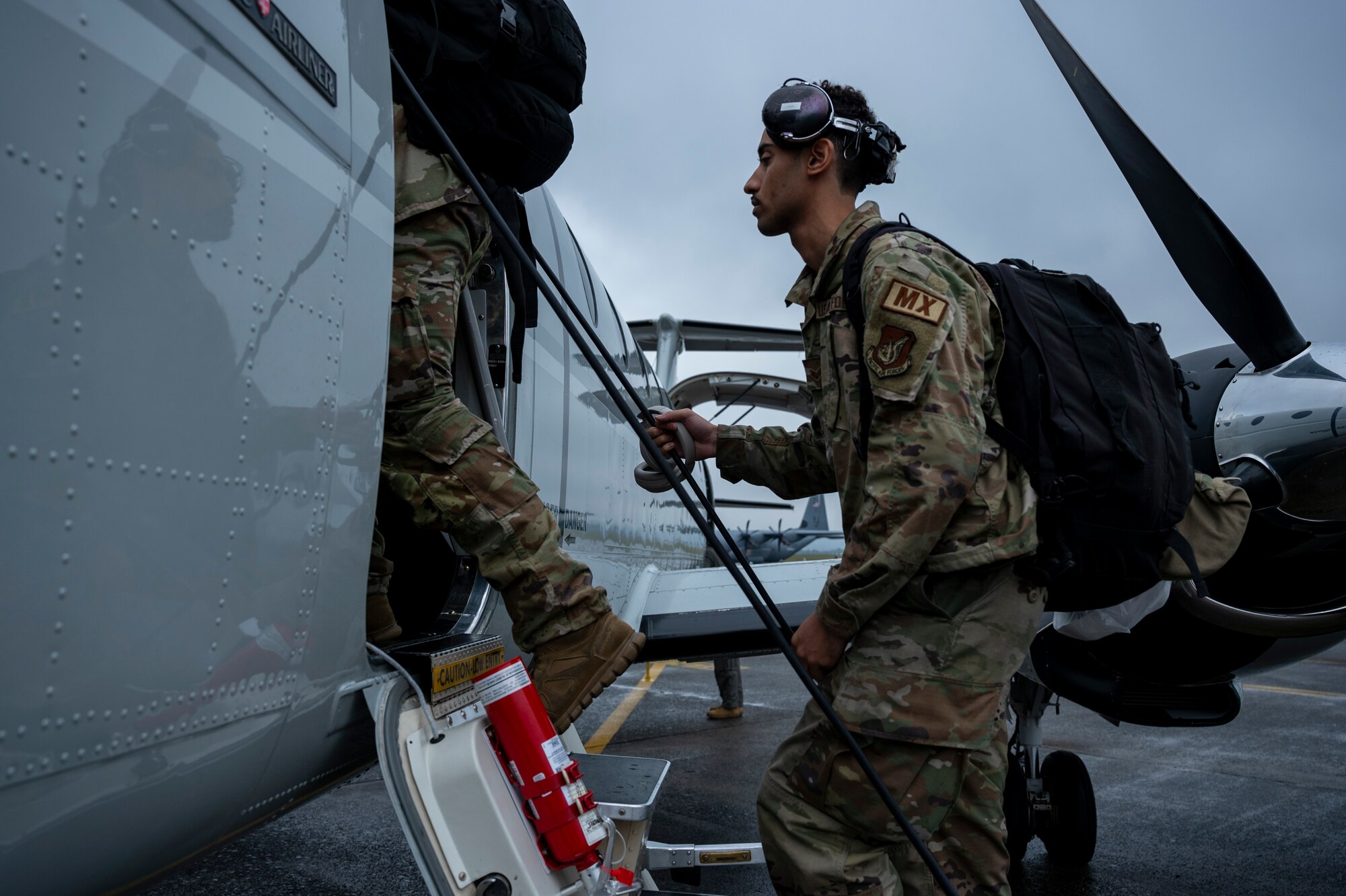 Military members board a C-12J aircraft.