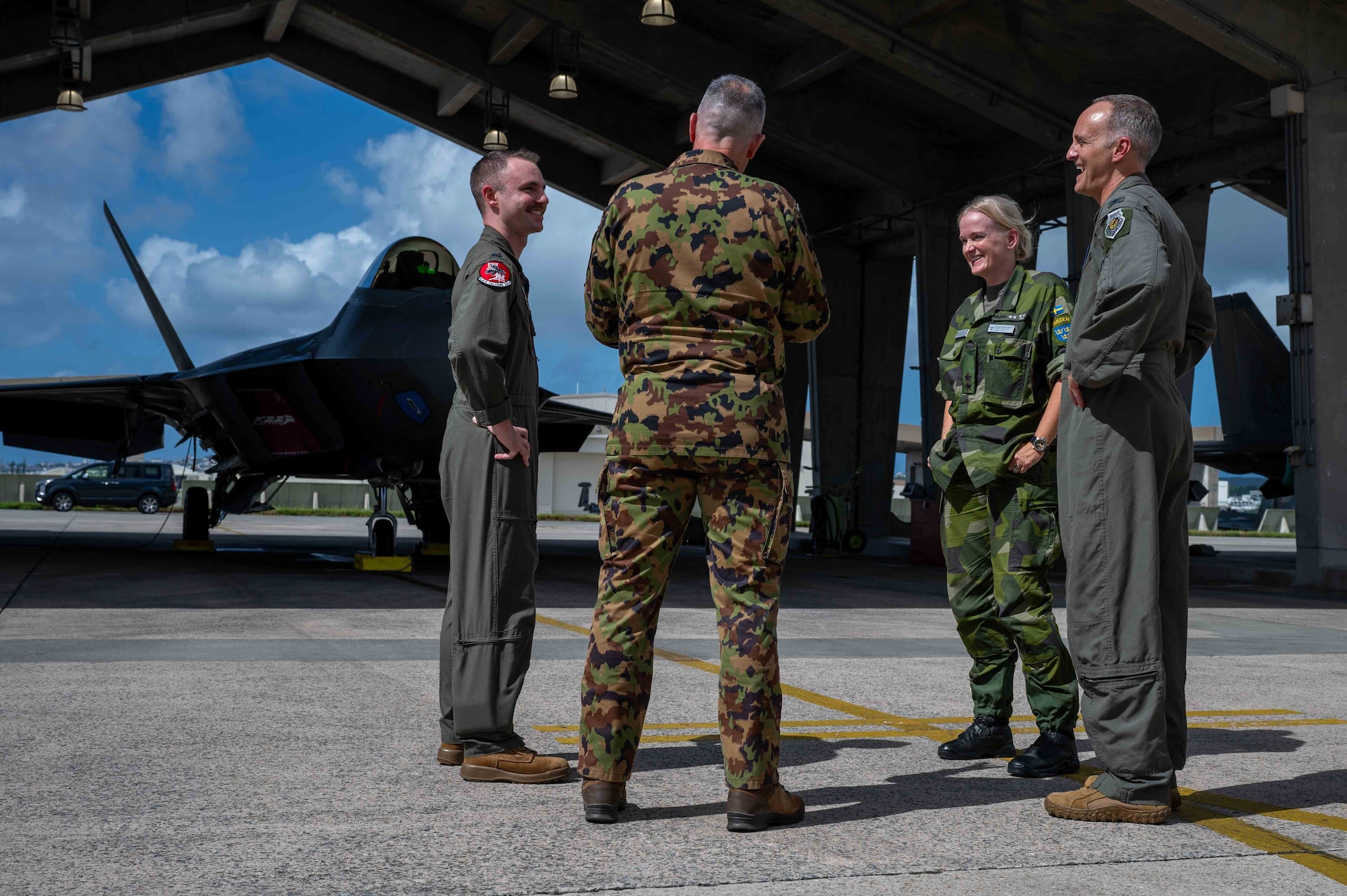 military members talk in front of a F-22A Raptor