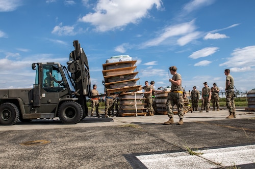 A forklift moving pallets of mattresses.