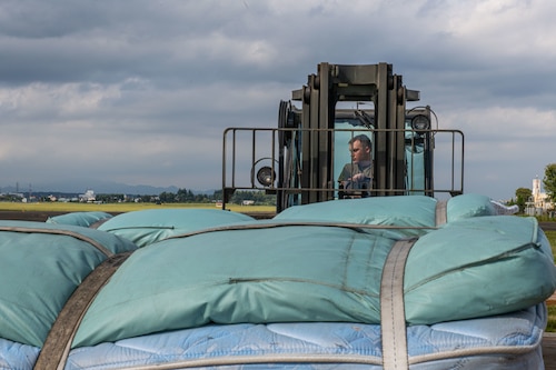 A forklift moving mattresses