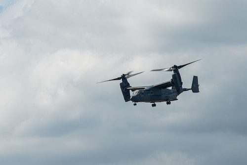 A grey CV-22 Osprey in flight with a cloudy background