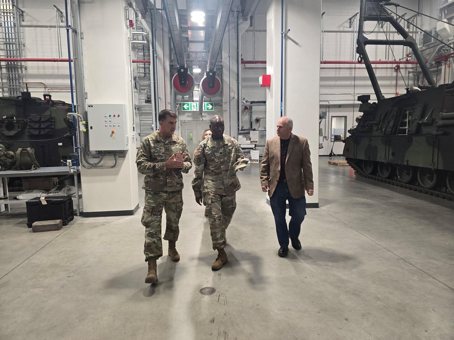The commander of Army Field Support Battalion-Poland, Lt. Col. Omar McKen, and the battalion’s deputy to the commander, John Glasgow, walks Brig. Gen. Todd Erskine through one of the facilities at the Powidz Army Prepositioned Stocks-2 worksite Oct. 21. The commanding general of the 310th Sustainment Command (Expeditionary) visited the Powidz APS-2 worksite to see how operations there can impact the integration of sustainment units into theater during contingency operations or exercises. (Cpt. James Bath)