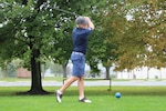 A man swings a golf club on a golf course