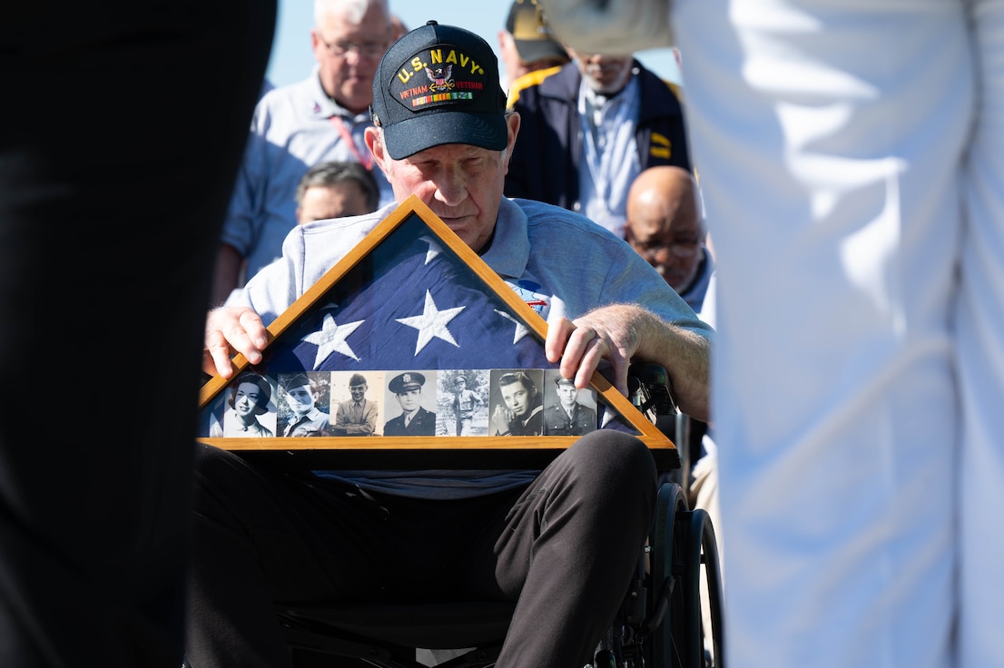 Phil Collins, U.S. Navy Vietnam War veteran, bows his head during the invocation portion of a Joint Service Color Guard posting of the colors during Honor Flight Chicago’s Day of Honor at the World War II Memorial in Washington, D.C., Oct. 23, 2024. The Honor Flight Chicago presents photos of service members on an American flag, related to the veterans attending, who either passed away before Honor Flight Chicago was formed or killed in action. (U.S. Air Force photo by Hayden Hallman)