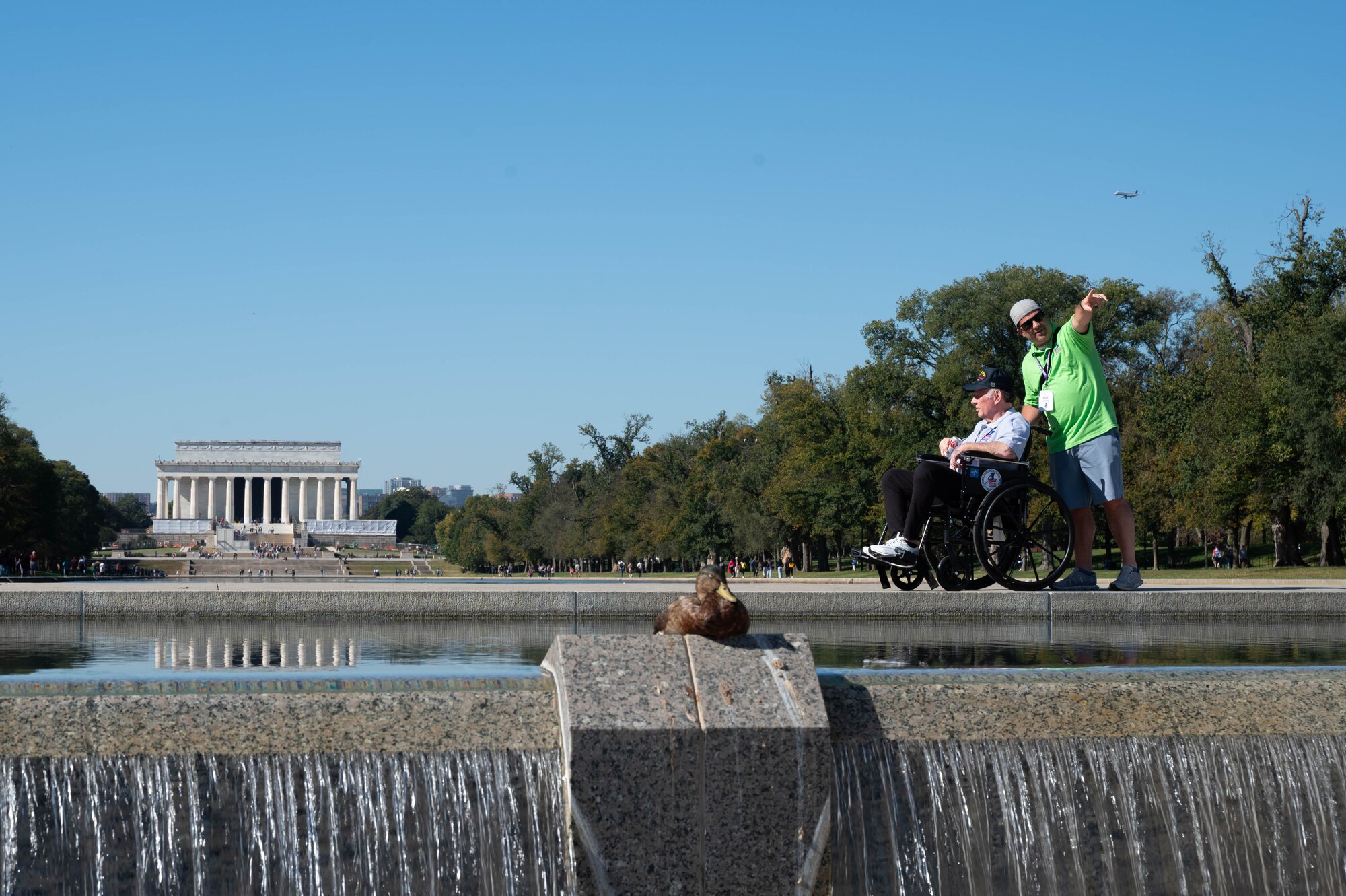 Phil Collins, U.S. Navy Vietnam War veteran, is accompanied by his son Ryan Collins at Honor Flight Chicago’s Day of Honor preceding a Joint Service Color Guard posting of the colors at the World War II Memorial in Washington, D.C., Oct. 23, 2024. Volunteer guardians can consist of family members and members of the public who wish to volunteer to ensure the safety and comfort of veterans. (U.S. Air Force photo by Hayden Hallman)