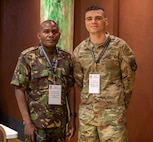 Two men in uniform pose for a photo