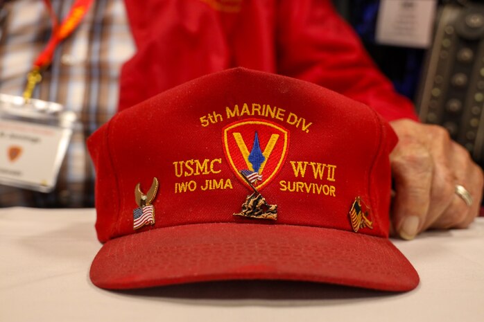 The hat of a World War II veteran sits on the table during a media question and answer session at the 74th annual 5th Marine Division  reunion on October 17, 2024, in San Antonio, Texas. Veterans of 5th MARDIV gather every year to share stories and continue conversation of their legacy. 5th MARDIV has activated twice in history; first for service in WWII and last for reinforcement of the Vietnam War. (U.S. Marine Corps photo by Cpl. Jonathan Baez)